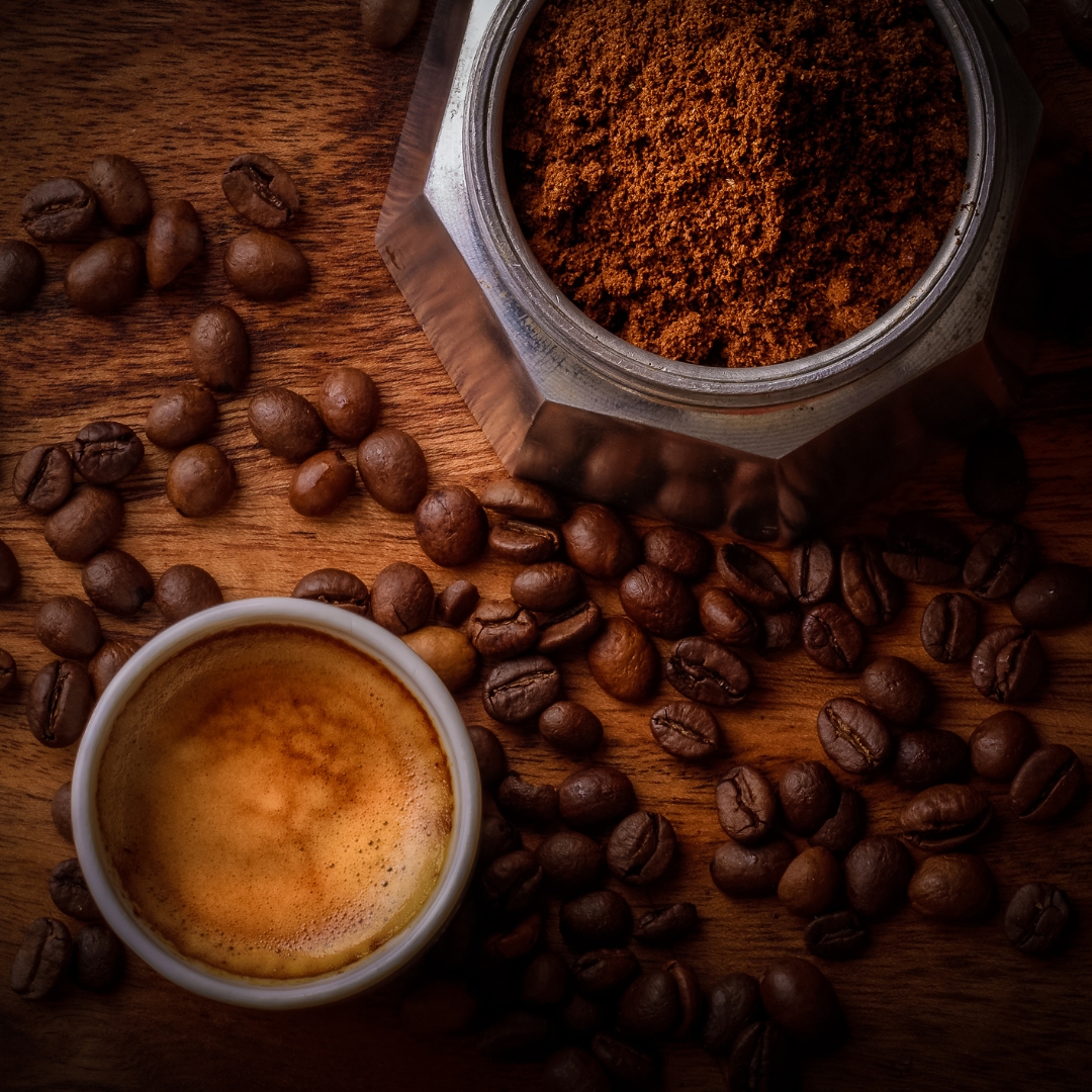 Freshly brewed coffee with coffee grounds and beans 