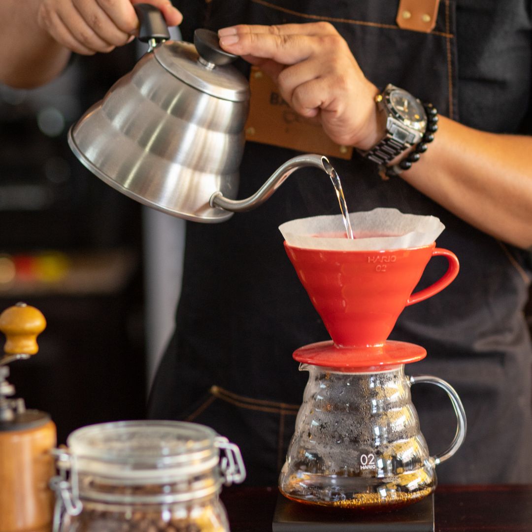 person pouring hot water over ground coffee