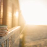 person on balcony drinking coffee